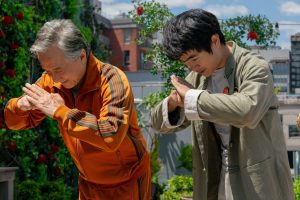 Image promotionnelle du film Karaté Kids: Legends, où l'on voit deux hommes pencher le buste dans un salut traditionnel.