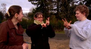 Une photo extrait du film. Il y a 3 enfants qui signent en LSF