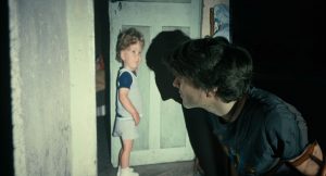 Photographie d'un home de profil qui regarde une photo sur un vidéoprojecteur