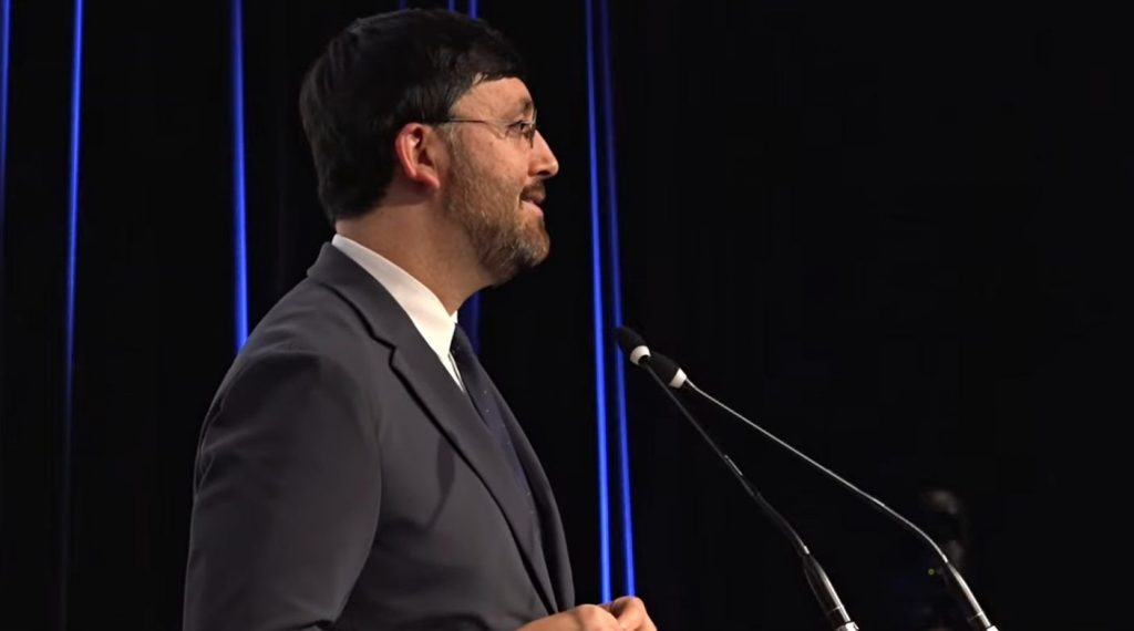 Gaëtan Bruel, président du CNC, en costume, face au pupitre.