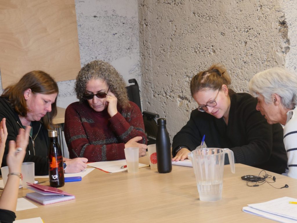 Isabelle, Leïla, Aurélie et Joachim autour d'une table durant un temps de réflexion par groupe.