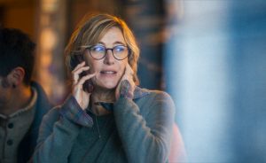 Une femme blonde, l'air inquiet, est au téléphone.