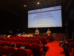L'équipe de Ciné Sens, devant une toile de cinéma, anime un atelier de sensibilisation.
