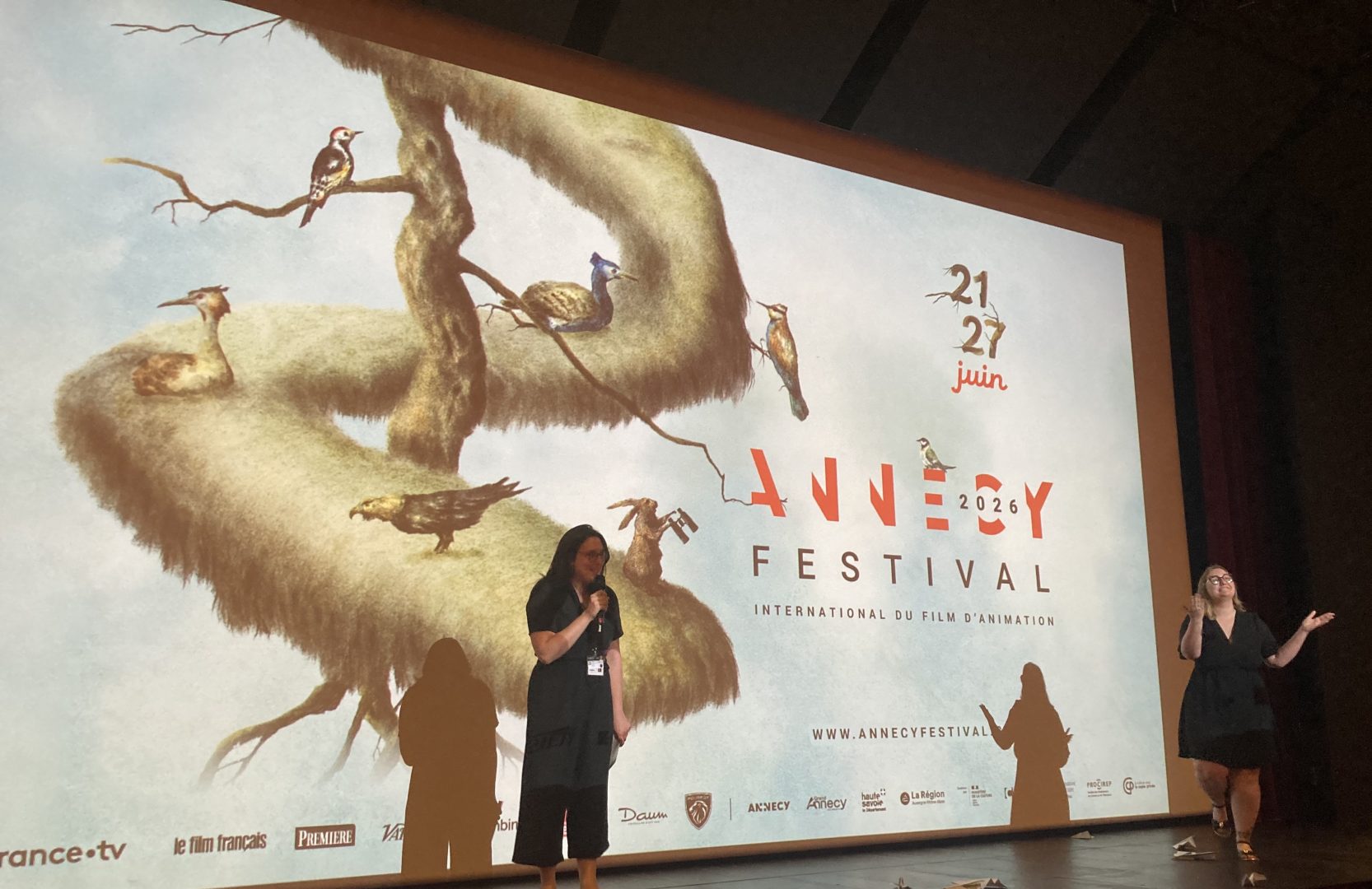 Sur l'estrade devant la toile de projection Eloïse Pommiès, chargée de l'action culturelle, présente la séance à venir du film Le Corset.