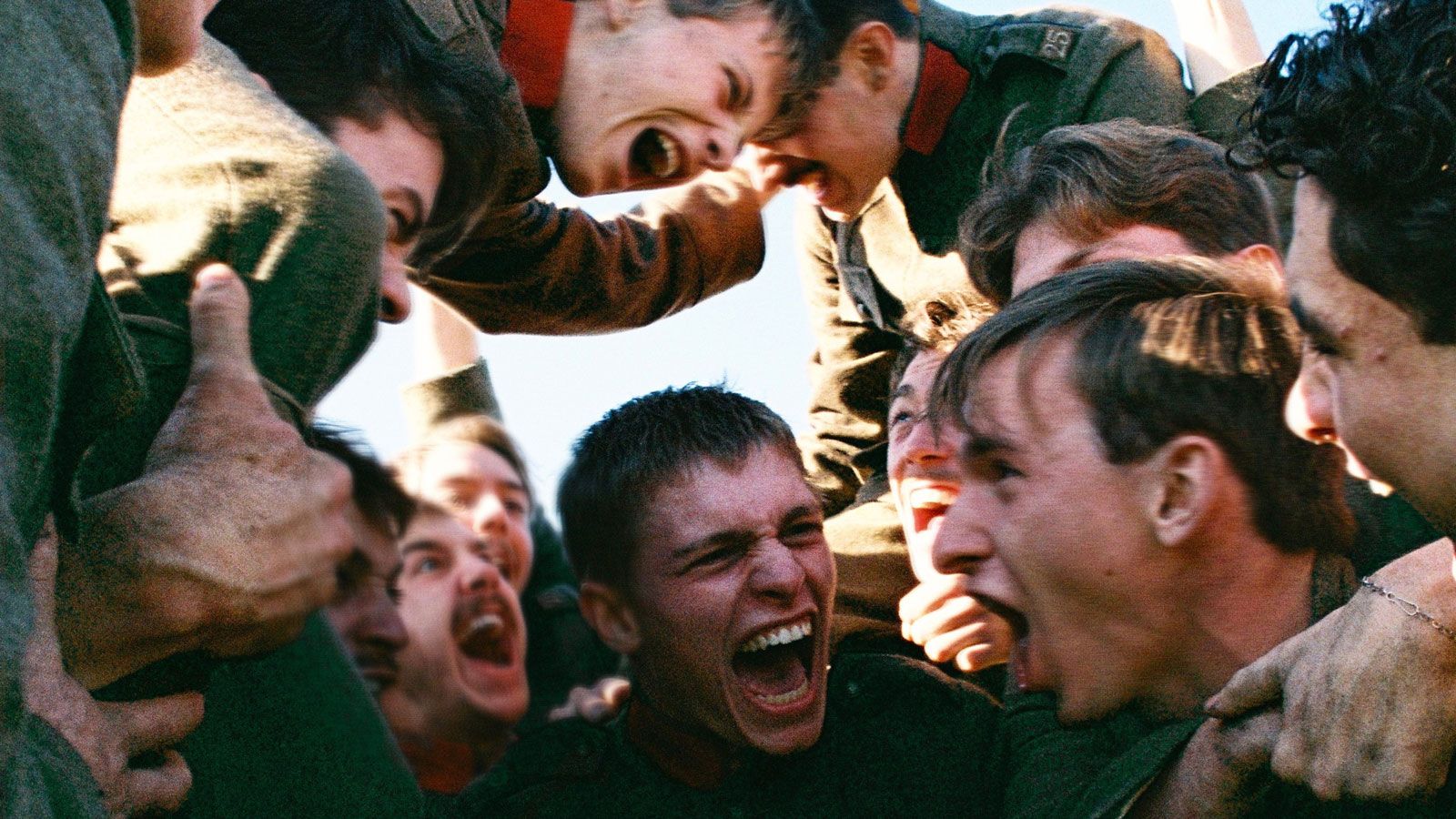 Un groupe de jeunes hommes font cercle en criant. Photo extraite du film Les braves